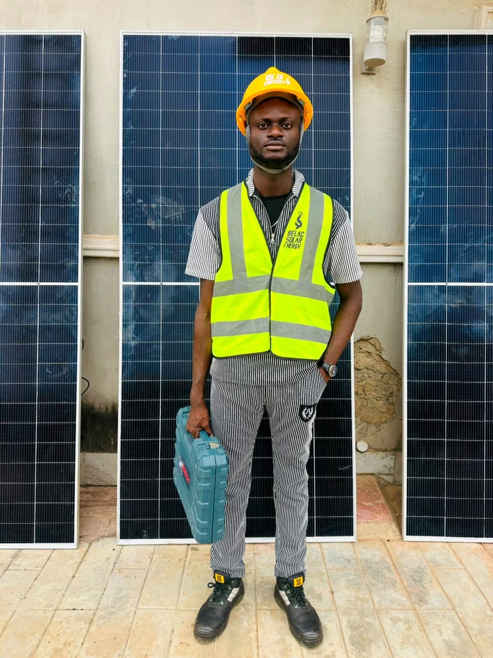 Belac Solar Energy technician in front of installed solar panel array